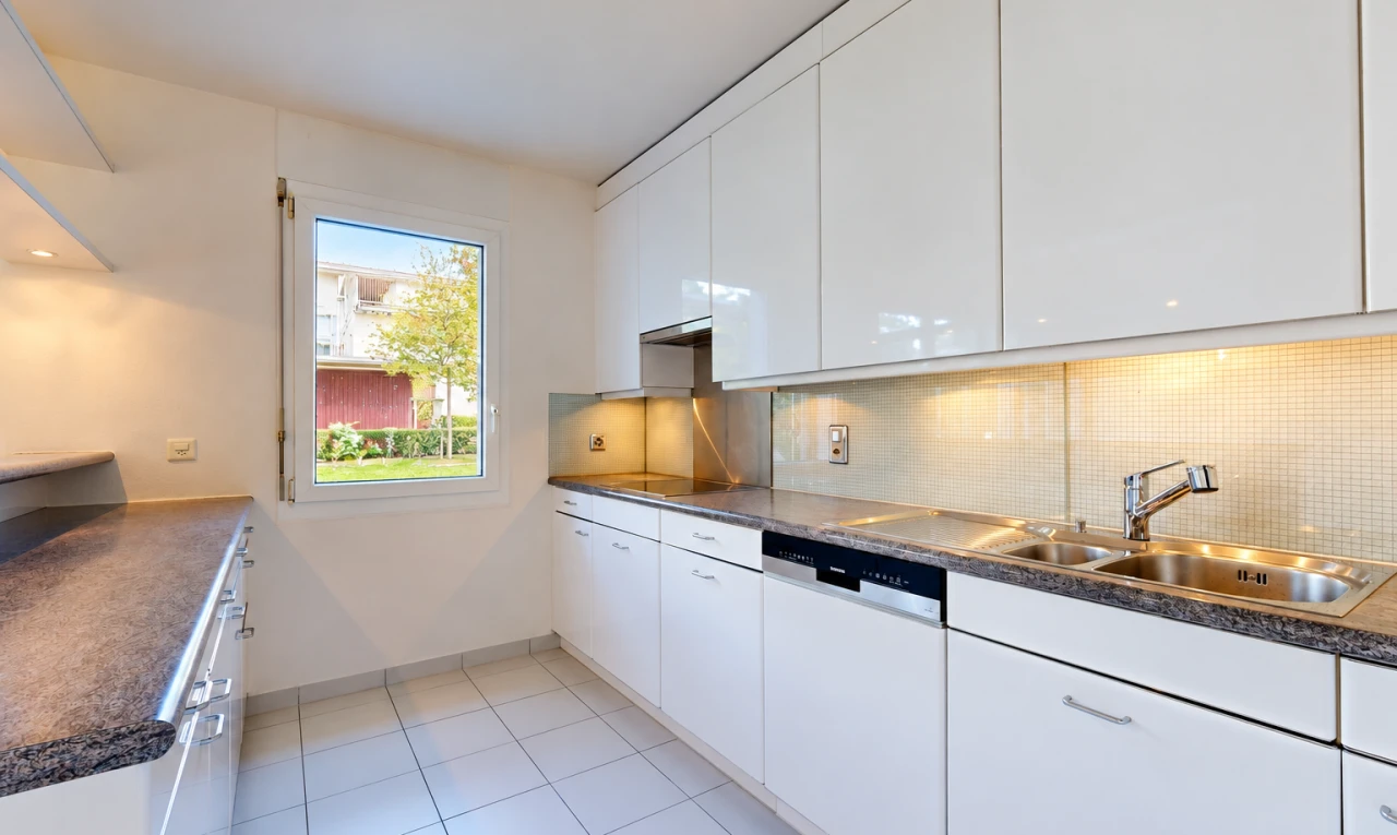 cuisine avec dark countertops, plans de travail, white cabinets, armoires blanches, et light floor
