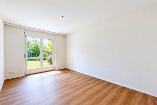 pièce vide avec accès à l'extérieur, cloison sèche, drywall, sol en finition bois, et wood finish floor