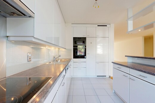 cuisine avec hotte, plaque de cuisson, plans de travail, dark countertops, et armoires blanches