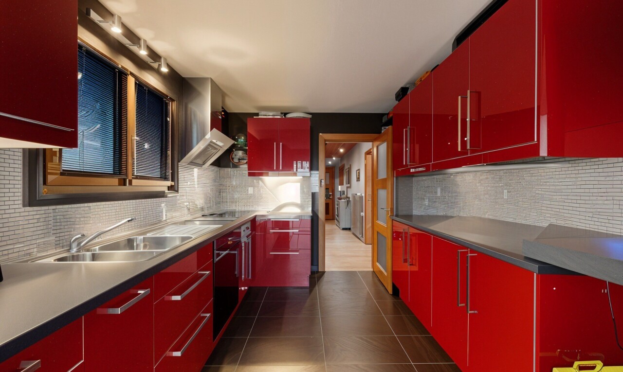 cuisine avec armoires rouges, dosseret, backsplash, tile floor, et inside property