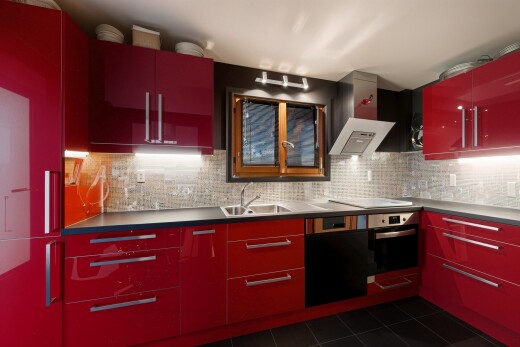 cuisine avec armoires rouges, armoires à panneau plat, dosseret, backsplash, et tile floor