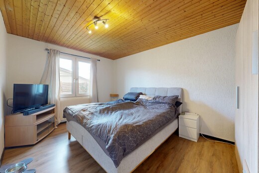 chambre avec wood ceiling, plafond en bois, télévision, wood finish floor, et sol en finition bois