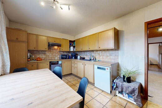 cuisine avec armoires marron clair, plans de travail, lave-vaisselle, inside property, et tile floor