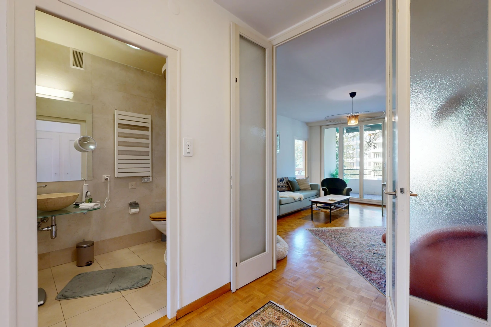 salle de bains avec miroir, radiateur, sol en finition bois, wood finish floor, et toilette