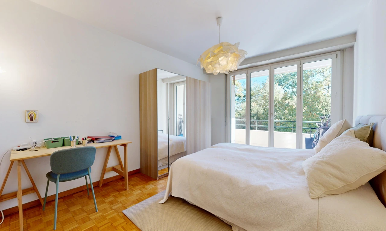chambre avec cloison sèche, drywall, éclairage suspendu, sol en finition bois, et wood finish floor