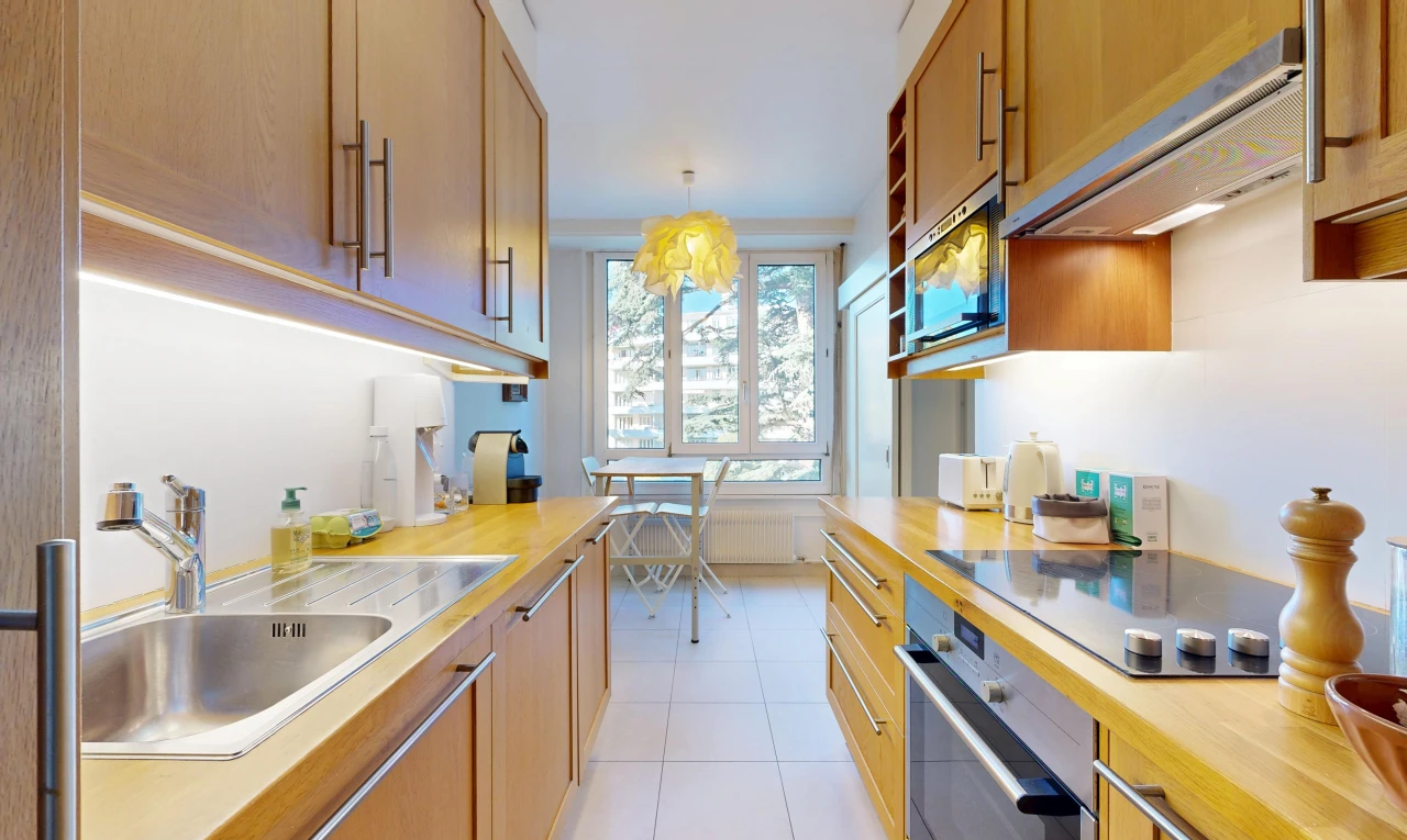 cuisine avec évier, hotte, light countertops, light floor, et four