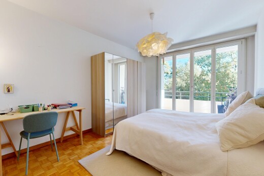 zimmer / schlafzimmer mit gipskartonwand, drywall, pendelleuchte, holzfußboden, und wood finish floor