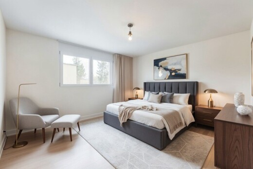 chambre avec wood finish floor, sol en finition bois, drywall, cloison sèche, et natural light