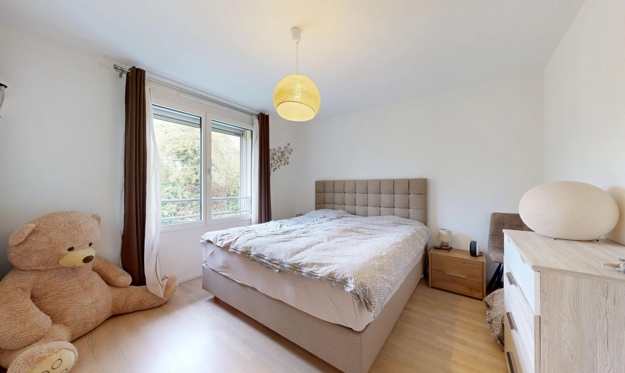 chambre avec éclairage suspendu, cloison sèche, drywall, sol en finition bois, et wood finish floor