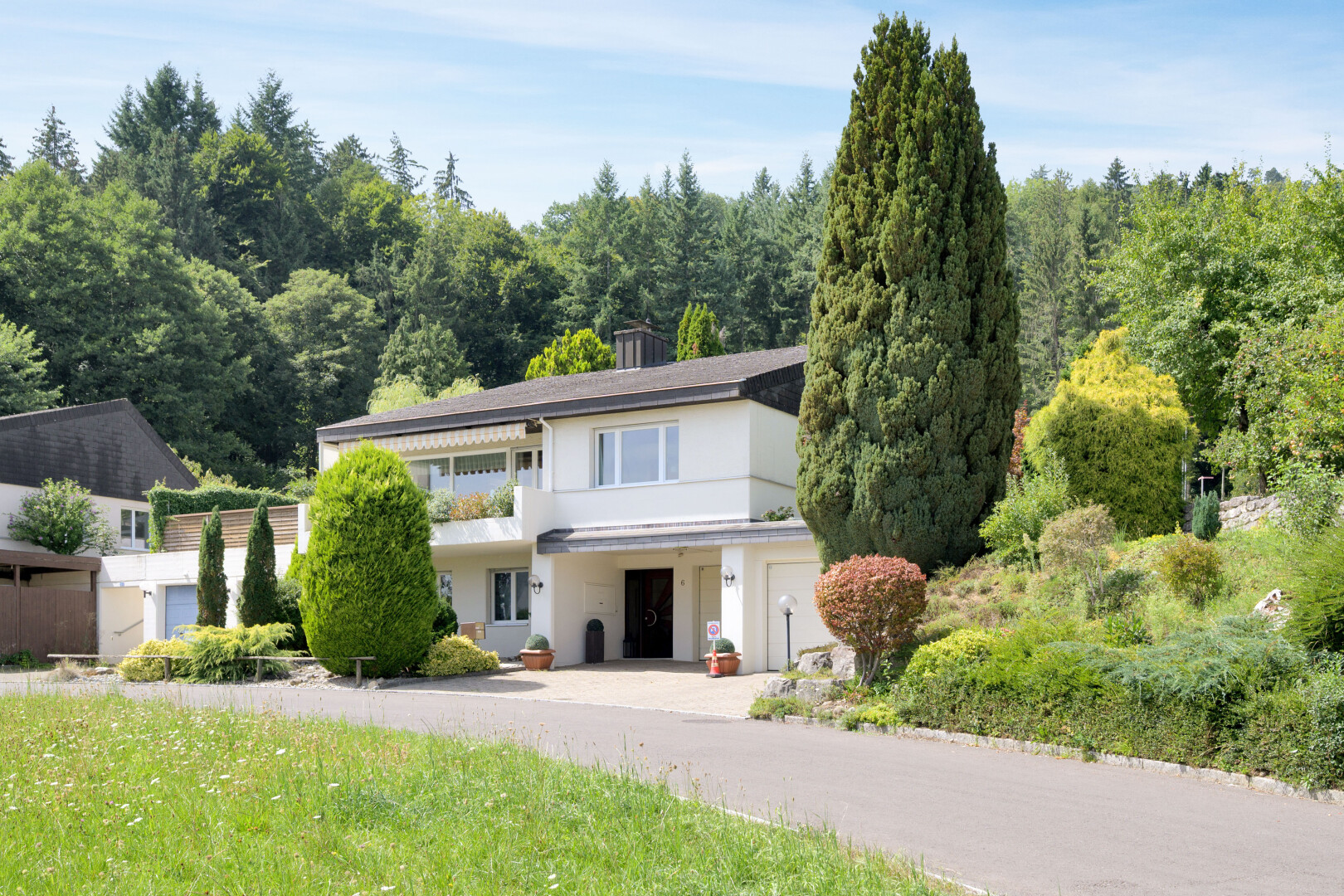 außenansicht mit balkon, waldblick, forest view, property visible, und eingebaute garage