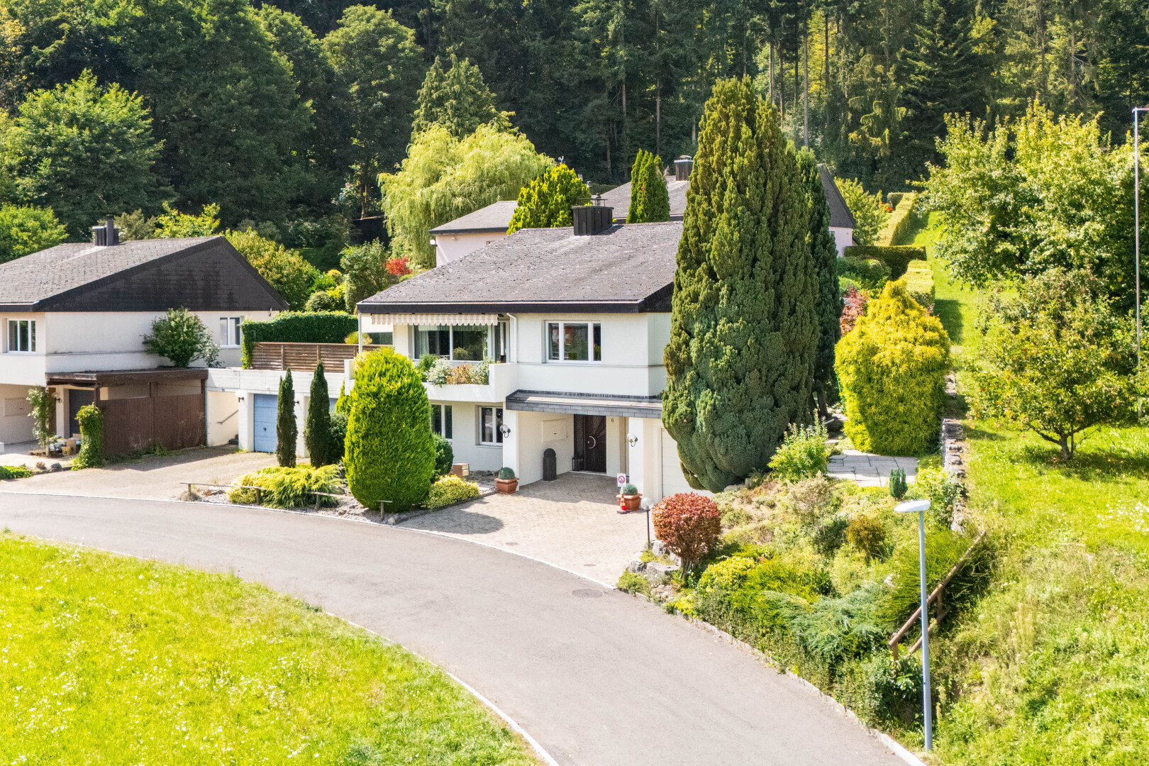 außenansicht mit integrierter carport, property visible, auffahrt, waldblick, und forest view