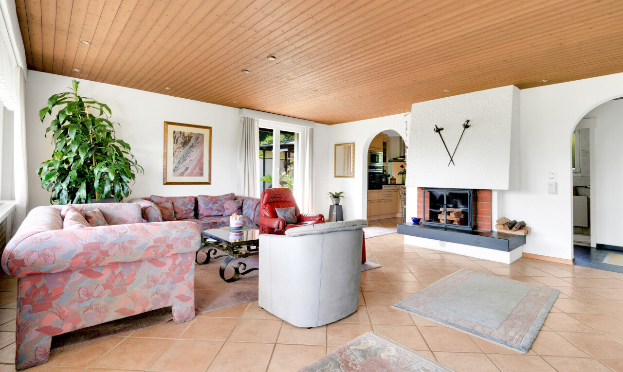 wohnzimmer mit gewölbte gehwege, kamin, natural light, natürliches licht, und tile floor