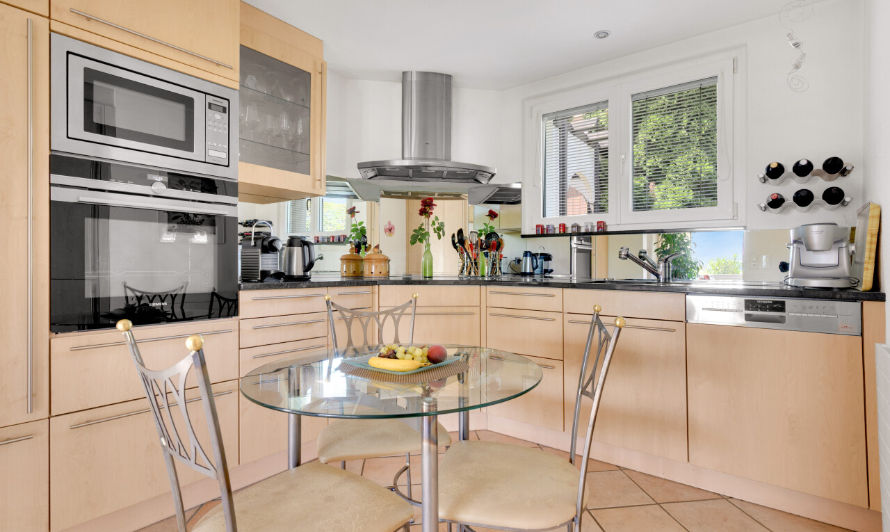 küche mit hellbraune schränke, ofen, natürliches licht, natural light, und tile floor