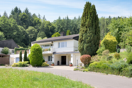 außenansicht mit balkon, waldblick, forest view, property visible, und eingebaute garage