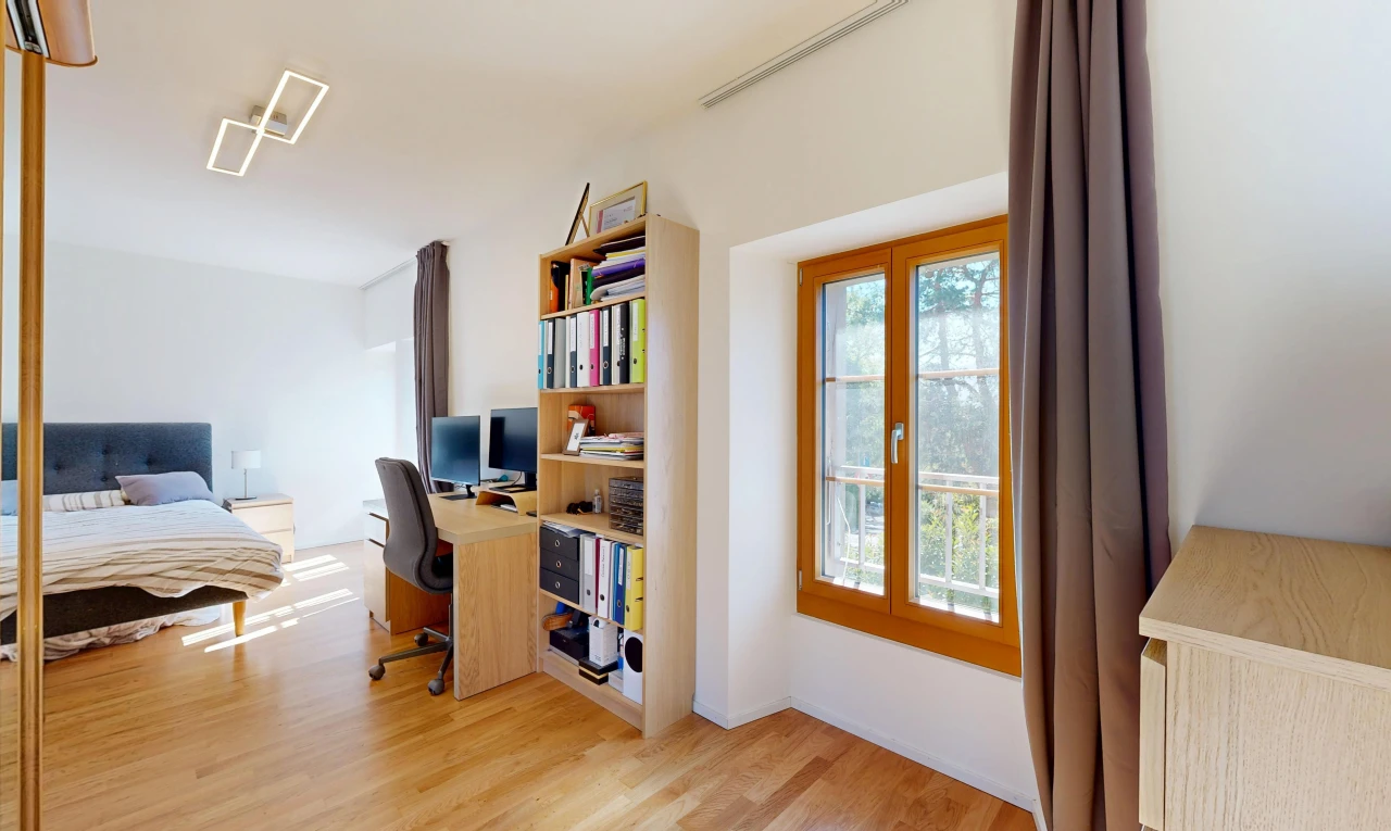 chambre avec espace bureau, drywall, cloison sèche, wood finish floor, et sol en finition bois