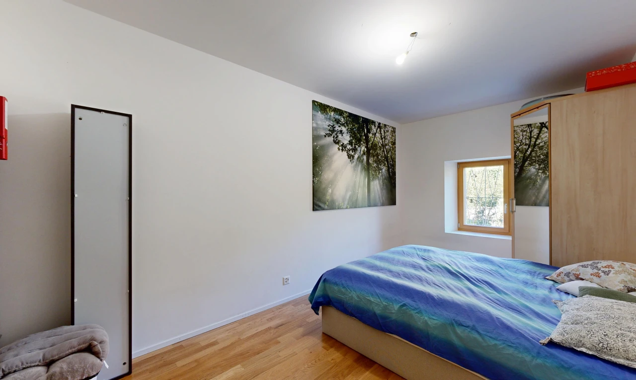 chambre avec drywall, cloison sèche, lumière naturelle, wood finish floor, et sol en finition bois