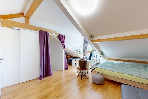room with beam ceiling, light wood-type flooring, and a closet
