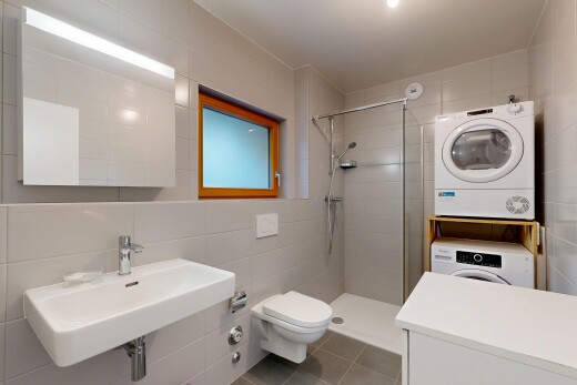 full bathroom featuring tile walls, a shower stall, stacked washer and clothes dryer, and tile patterned floors