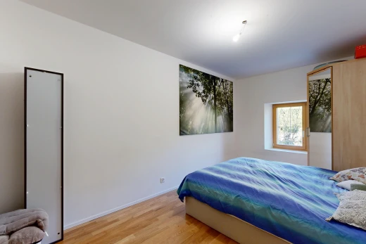 chambre avec drywall, cloison sèche, lumière naturelle, wood finish floor, et sol en finition bois