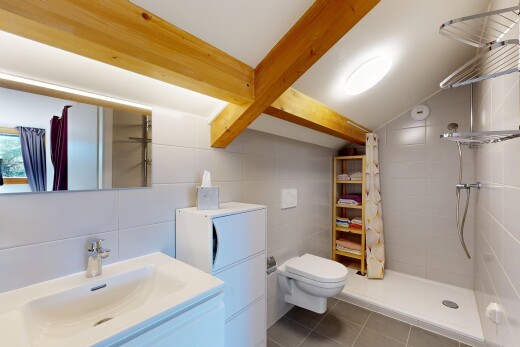 bathroom featuring a stall shower, tile walls, vanity, dark tile patterned flooring, and beamed ceiling
