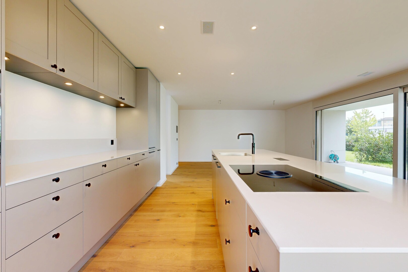 kitchen with light countertops, a large island, recessed lighting, light wood finished floors, and black electric cooktop