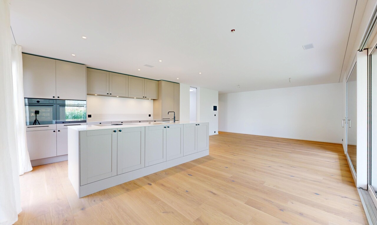 kitchen with light countertops, a kitchen island with sink, light wood-style flooring, recessed lighting, and double oven