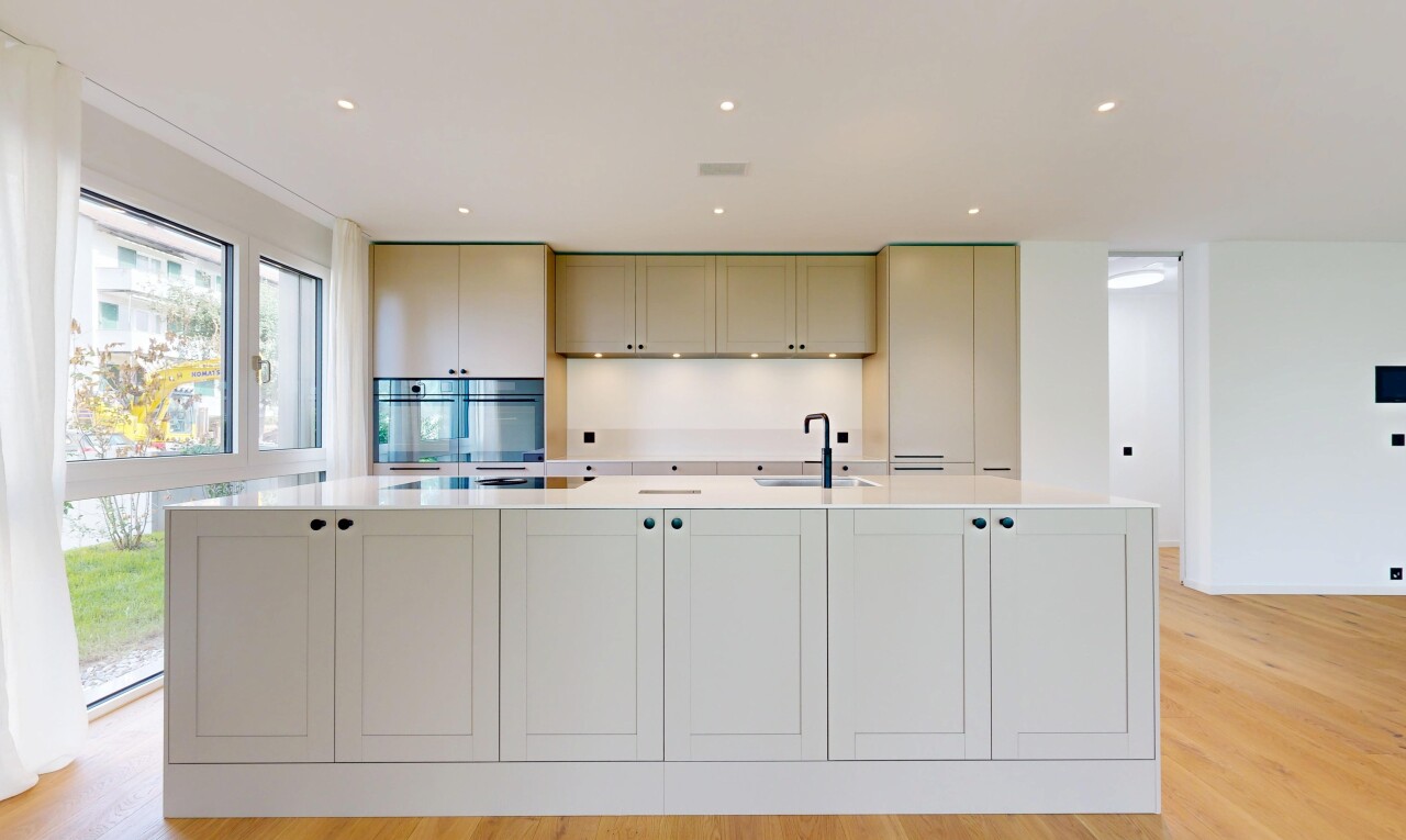 kitchen featuring light stone countertops, a large island with sink, light wood-style floors, and recessed lighting