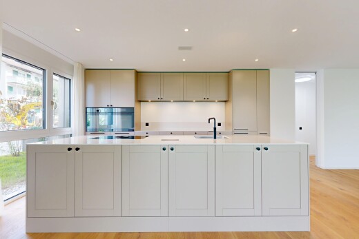 kitchen featuring light stone countertops, a large island with sink, light wood-style floors, and recessed lighting
