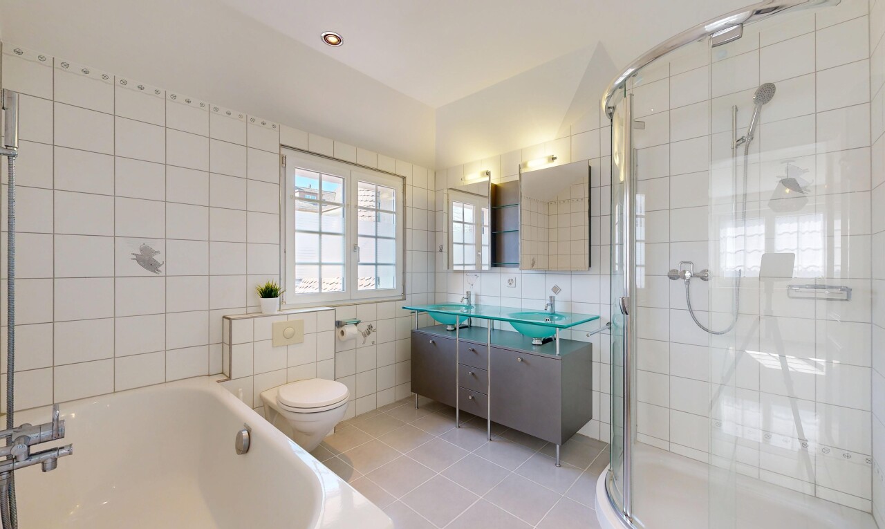 salle de bains avec toilette, miroir, salle de bain complète, mur en carrelage, et tile wall