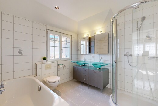 salle de bains avec toilette, miroir, salle de bain complète, mur en carrelage, et tile wall