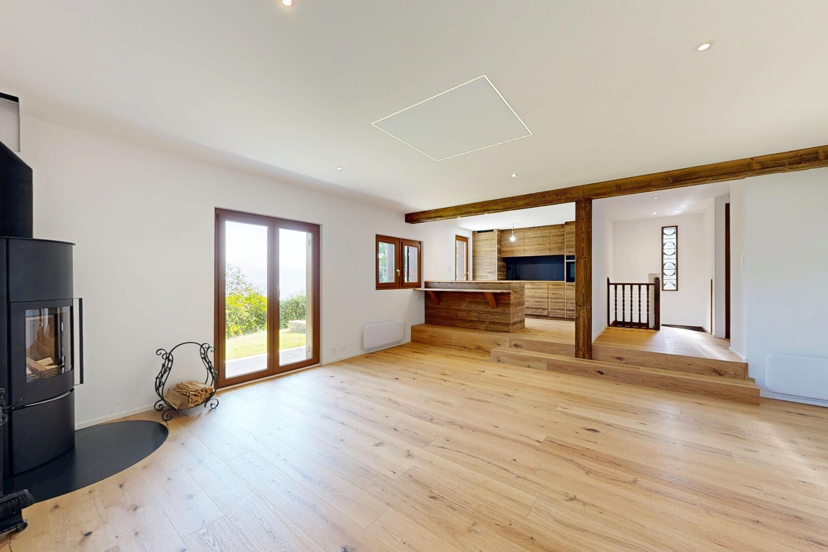 pièce vide avec poêle à bois, sol en finition bois, wood finish floor, inside property, et lumière naturelle
