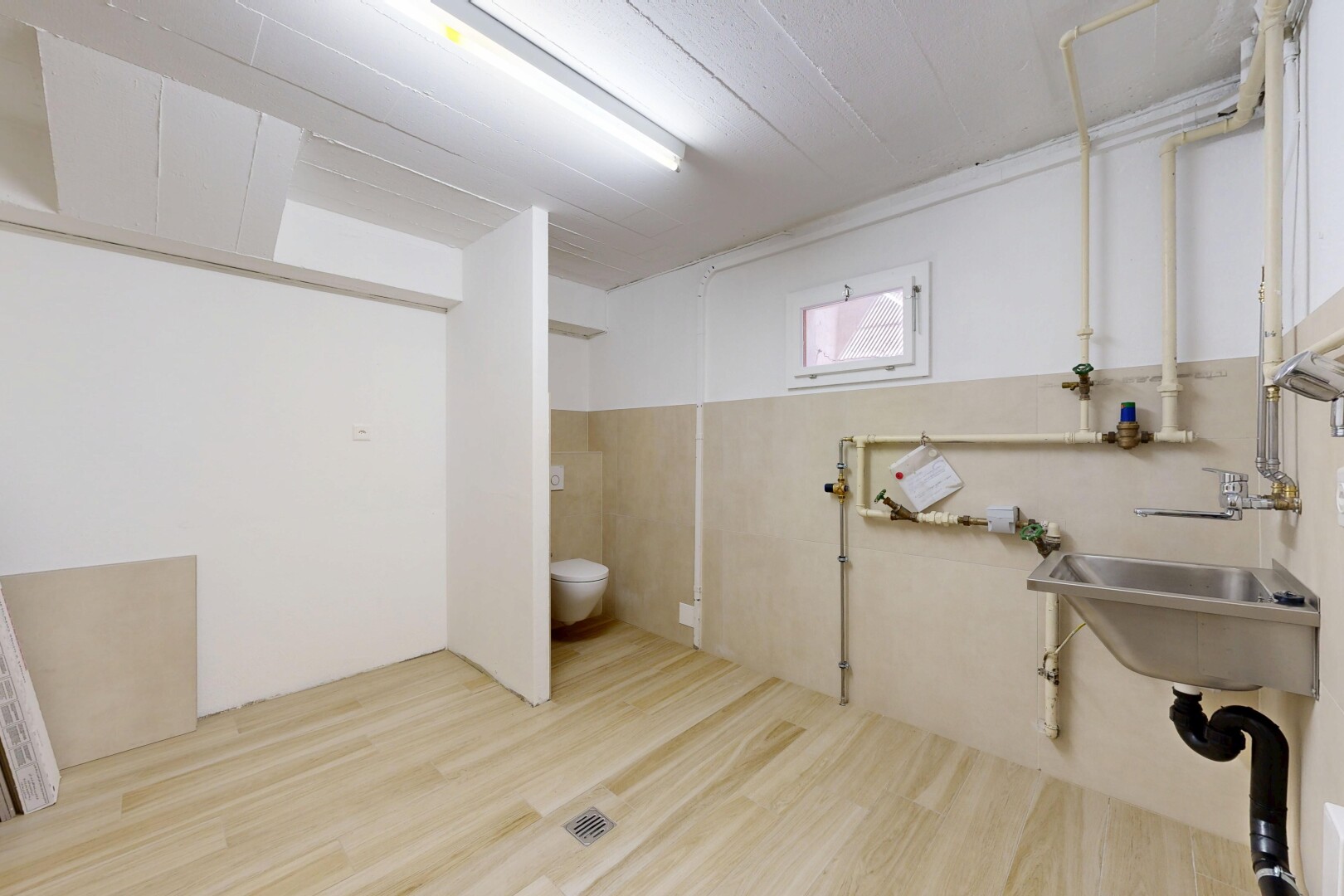 salle de bains avec inside community, évier, sous-sol, wood finish floor, et drywall