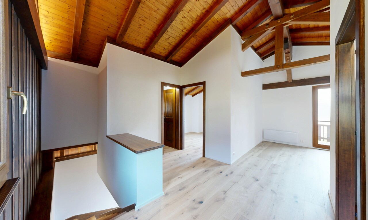 pièce vide avec inside property, sol en finition bois, wood finish floor, plafond à poutres, et beamed ceiling