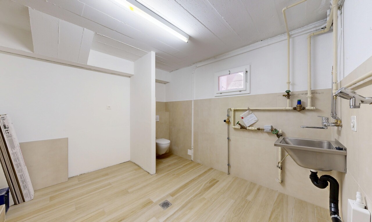 salle de bains avec inside community, évier, sous-sol, wood finish floor, et drywall