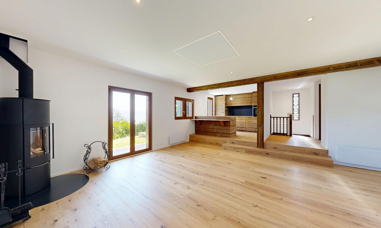 pièce vide avec poêle à bois, sol en finition bois, wood finish floor, inside property, et lumière naturelle