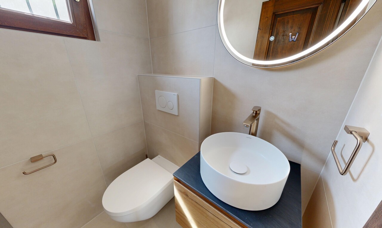 salle de bains avec toilette, miroir, inside property, évier, et lavabo (ou coiffeuse selon le contexte)