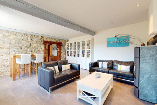 wohn- / esszimmer mit steinwand und balkendecke