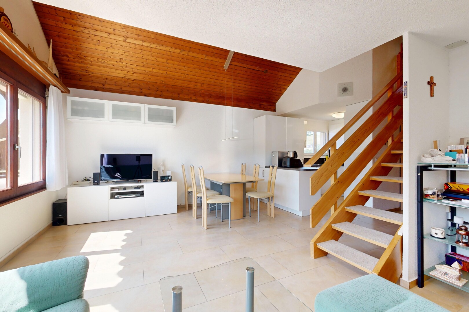salon / salle à manger avec escaliers, vaulted ceiling, plafond voûté, télévision, et drywall
