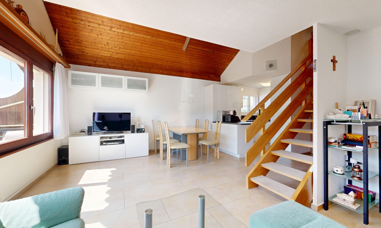 salon / salle à manger avec escaliers, vaulted ceiling, plafond voûté, télévision, et drywall