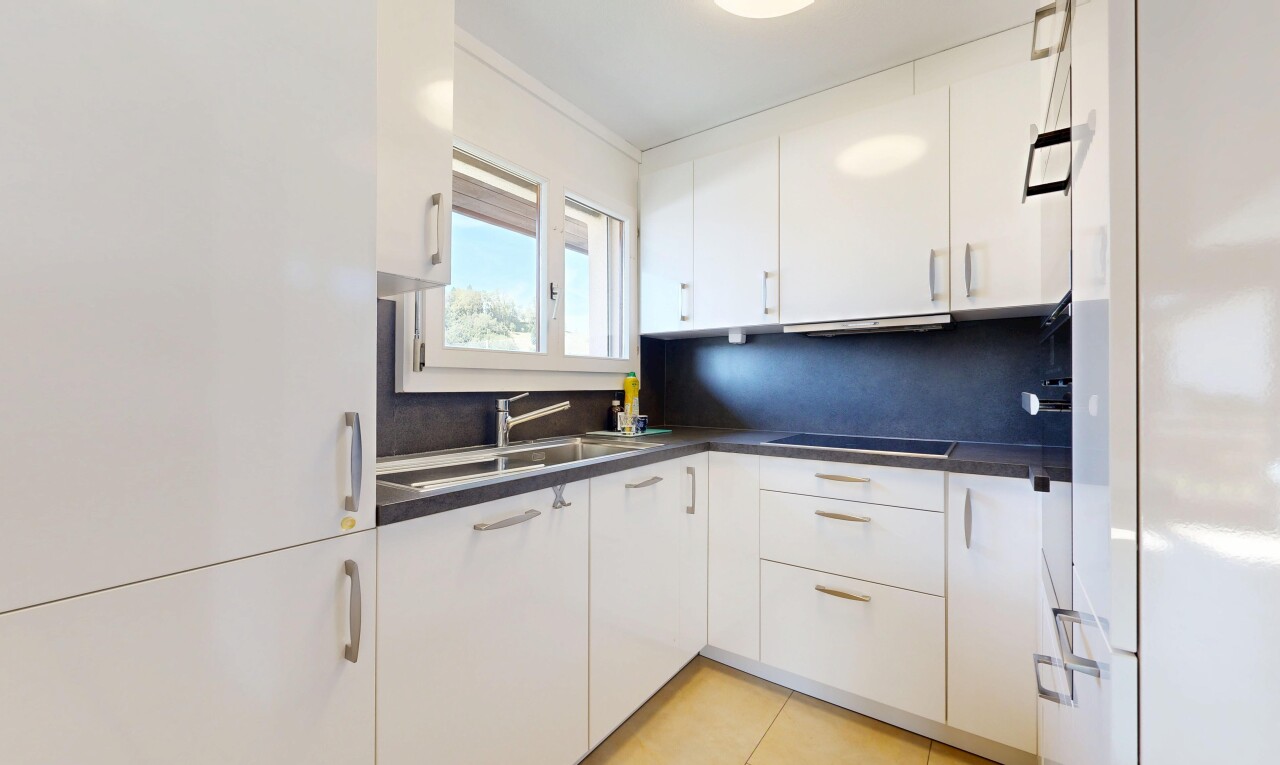 cuisine avec plans de travail, dark countertops, armoires blanches, white cabinets, et évier