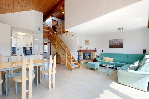 living room with a tile fireplace and a high wood beamed ceiling