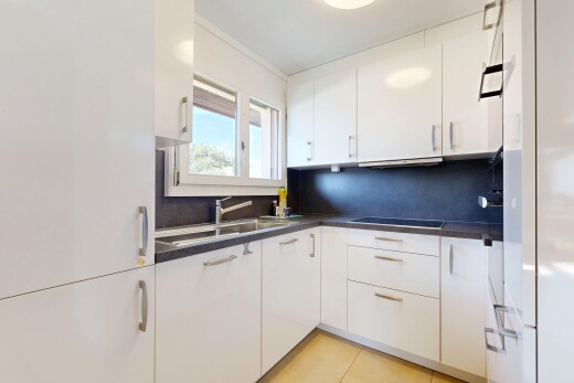 cuisine avec plans de travail, dark countertops, armoires blanches, white cabinets, et évier