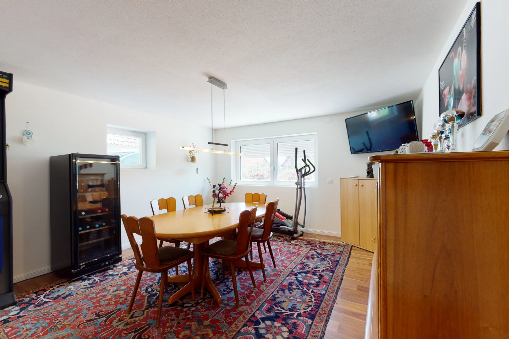 salle à manger avec parquet, lumière naturelle, et télévision