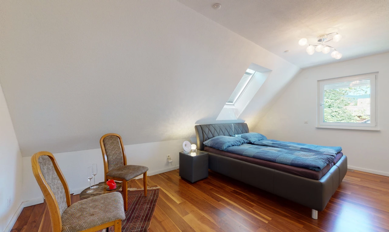 chambre à coucher avec lumière naturelle, plafond voûté, et parquet
