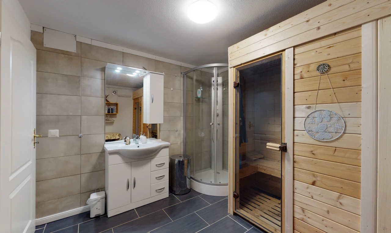 salle de bains avec carrelage, vasque, douche, porte de douche, meuble-lavabo, et miroir
