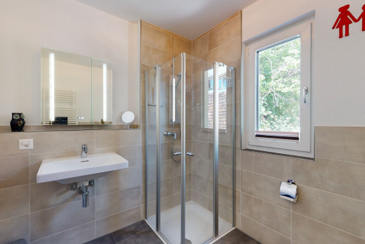 bathroom featuring a wealth of natural light, radiator, multiple mirrors, shower booth, and sink