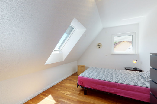 bedroom featuring lofted ceiling with skylight, natural light, and hardwood floors