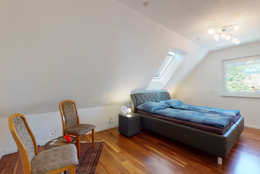 hardwood floored bedroom with natural light and vaulted ceiling