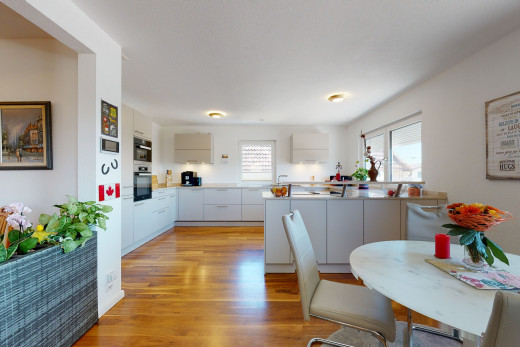 küche mit natürlichen licht, ofen, hellen hartholzböden und weissen schränken