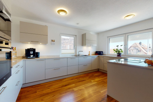 küche mit hartholzboden, natürlichem licht und weissen schränken